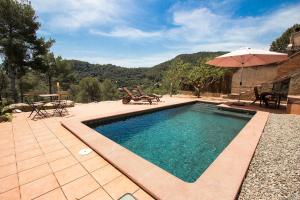 a swimming pool with a table and an umbrella at Catalunya Casas Nature & Tranquility only 25kms from Barcelona in Torrelles de Llobregat