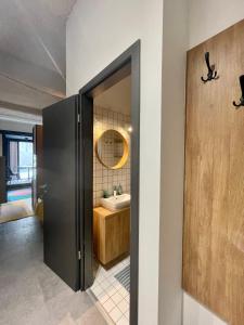 Design Boutique INBP110 Studio Apartment #freeparking في بودابست: حمام بباب اسود ومغسلة
