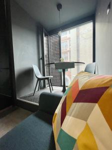 Design Boutique INBP110 Studio Apartment #freeparking في بودابست: غرفة نوم بسرير وطاولة وكراسي