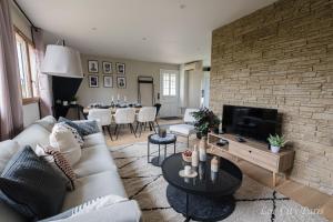 a living room with a couch and a tv at Maison de Charme - Parc Asterix - proche Mer de Sable - Villepinte - Aéroport CDG in Ermenonville