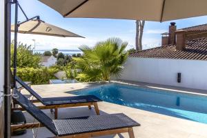 a swimming pool with a chair and an umbrella at Catalunya Casas Exceptional Villa with sea views only 1800m to beach! in El Vendrell