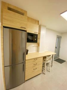 a kitchen with a stainless steel refrigerator and a table at Camiño Vello 2 in Viveiro