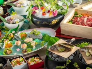 una mesa cubierta con platos de alimentos y plantas en Azumaen en Unzen