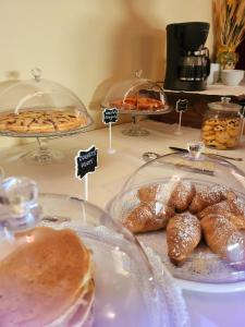 una mesa llena de diferentes tipos de bollería y pan en Hotel Federico II, en Castiglione di Sicilia