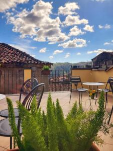 een patio met stoelen en tafels op een balkon bij Hotel Federico II in Castiglione di Sicilia