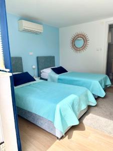 2 camas en una habitación con paredes azules en Madonna Guesthouse II, en Dubrovnik