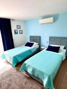 dos camas sentadas una al lado de la otra en un dormitorio en Madonna Guesthouse II, en Dubrovnik