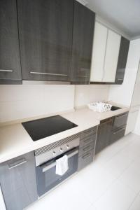 uma cozinha com armários a preto e branco e um fogão em Oriente DNA Studios V em Lisboa