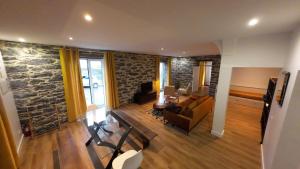 a living room with a stone wall at Souza Beach Apartment - Porto da Cruz - Studio & Suite in Porto da Cruz
