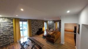 ein Wohnzimmer mit einer Steinmauer in der Unterkunft Souza Beach Apartment - Porto da Cruz - Studio & Suite in Porto da Cruz