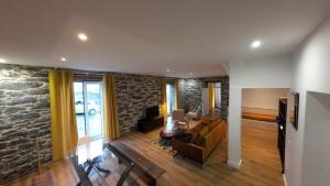 a living room with a stone wall at Souza Beach Apartment - Porto da Cruz - Studio & Suite in Porto da Cruz