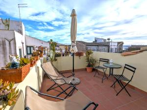 a patio with chairs and a table and an umbrella at La Casa Delle Fate in Siracusa