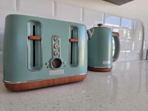 a toaster sitting on a counter next to two cups at Corner Cottage in Cape Town
