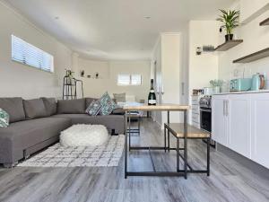 un salon avec un canapé et une table et une cuisine dans l'établissement Corner Cottage, au Cap 6 autres photos