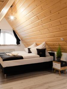 a bed in a room with a wooden ceiling at Royal Apartments & Spa Zakopane-Cyrhla in Zakopane