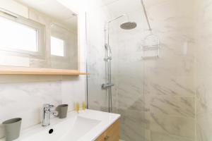a white bathroom with a sink and a shower at SELECT'SO HOME - T2 au cœur du Lavandou - Prestations de qualité - GAIA in Le Lavandou