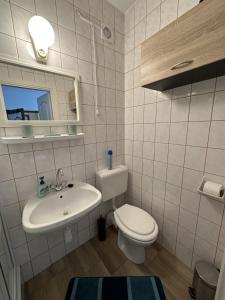 a bathroom with a sink and a toilet and a mirror at Haus Gizella in Harkány