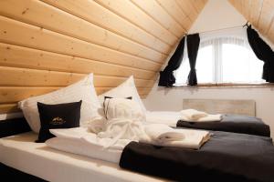 two beds in a room with wooden ceilings at Royal Apartments & Spa Zakopane-Cyrhla in Zakopane