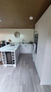 a kitchen with white cabinets and a counter top at Lyme View Lodge in Trent Vale