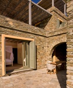a stone building with a patio with a table at Aegea Blue Cycladic Resort in Zorgos 