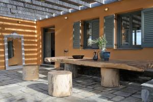 a large wooden table on a patio next to a building at Aegea Blue Cycladic Resort in Zorgos 
