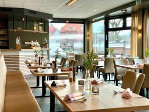 a restaurant with tables and chairs and a bar at Hotel Stadt Aurich in Aurich