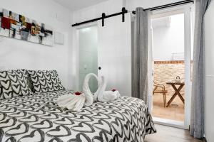 two white swans sitting on a bed in a bedroom at Casa Pedro in Vejer de la Frontera
