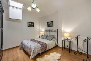 ein Schlafzimmer mit einem Bett, zwei Lampen und einem Teppich in der Unterkunft Casilla de Adela in Albuñuelas