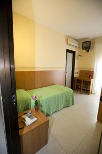 a hotel room with a bed and a desk and a table at Hotel Ganfo in Sirmione