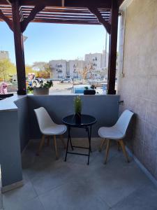a patio with two chairs and a table and a window at Apartment with terrace and parking in Eilat
