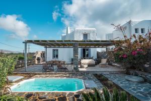 a villa with a swimming pool in front of a house at Alfa Luxury Villas in Chrissi Akti