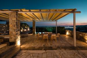 a patio with a table and chairs under a pergola at Alfa Luxury Villas in Chrissi Akti