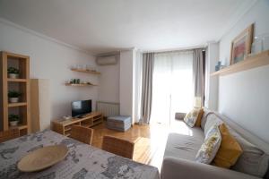 a living room with a couch and a television at Flat with parking in the center of Las Rozas in Las Rozas de Madrid