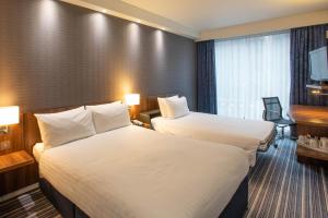 a hotel room with two beds and a television at Holiday Inn Express Manchester City Centre Arena by IHG in Manchester