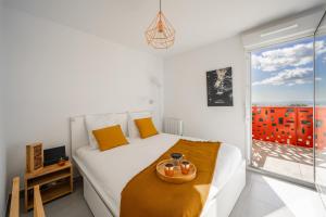 - une chambre blanche avec un lit et un plateau dans l'établissement Large and bright nest with a clear view of the sea, à Montpellier