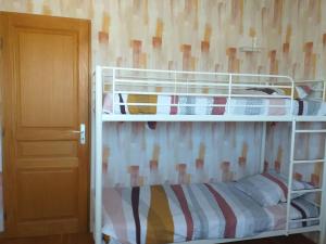 two bunk beds in a room with a door at Chez Mamie Riclaude in Orsan