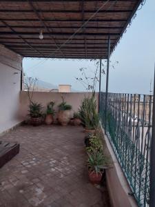 eine Terrasse mit Topfpflanzen und einem Zaun in der Unterkunft Dar Nineta in Fès