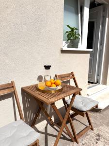 een houten tafel met een kom sinaasappels erop bij Madonna Guesthouse II in Dubrovnik