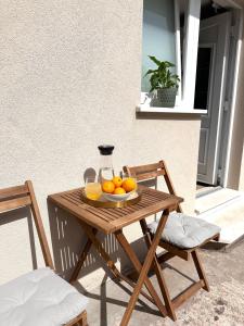 una mesa de madera con un tazón de naranjas. en Madonna Guesthouse II, en Dubrovnik