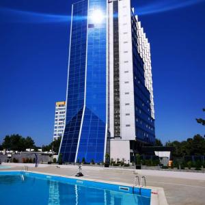a tall building with a pool in front of it at Euphoria Olimp in Olimp