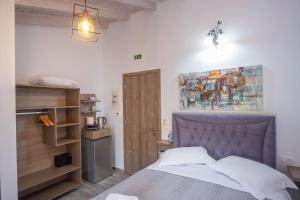 Serenity Luxe Suites في بارغا: غرفة نوم بسرير ودهان على الحائط