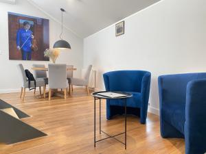 a living room with blue chairs and a table at MINT Luxury Apartments at the Main Square in Krakow