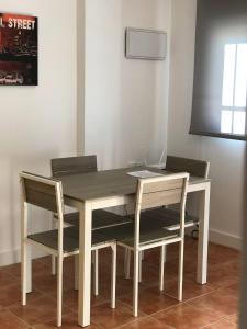 a wooden table with two chairs and a laptop on it at Apartamento Valdepasillas in Badajoz