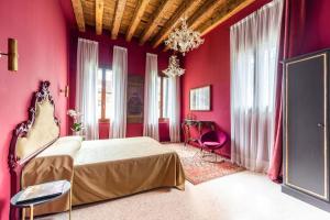 ein Schlafzimmer mit rosa Wänden und ein Bett in einem Zimmer in der Unterkunft Cà Regina Panada - passion on the Canal in Venedig