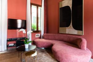 uma sala de estar com um sofá rosa e uma mesa em Cà Regina Panada - passion on the Canal em Veneza