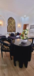Hotel Palace tanger في طنجة: غرفة معيشة بها أريكة وطاولة عليها زهور