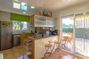 a kitchen with a counter and stools in it at Catalunya Casas Unique Costa Brava Abode with train access to BCN in Sils