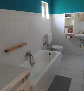 a bathroom with a tub and a toilet and a sink at Holiday Apartment in Badacsonytördemic