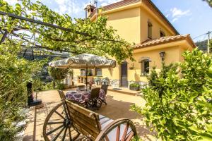 a patio with a table and chairs and an umbrella at Catalunya Casas Spacious, Sublime Villa just 15km to Barcelona! in Torrelles de Llobregat