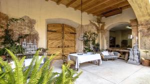 patio con mesa, sillas y puerta de madera en Catalunya Casas Breathtaking 18th Century Converted Convent!, en Vilarrodona